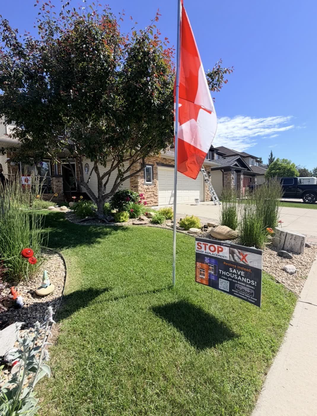 Ladder and NuRoof yard sign at a Nano Shield job in a Calgary neighborhood